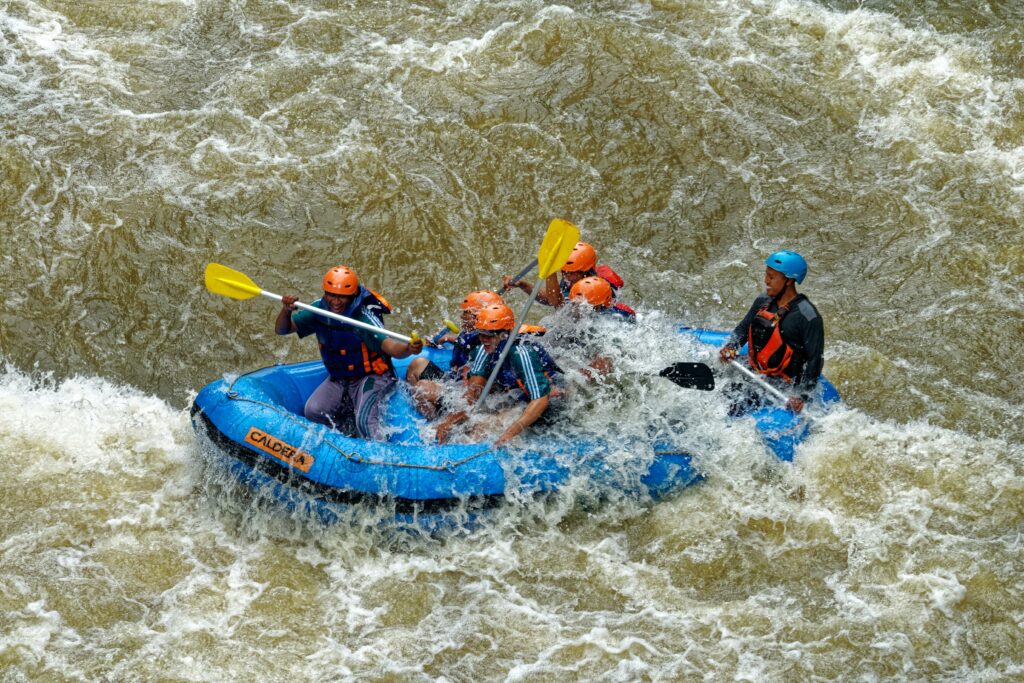 People Rafting in River