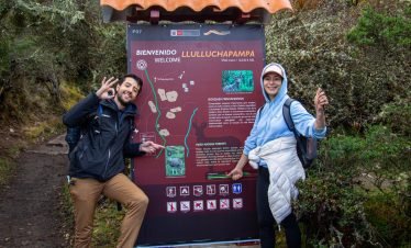 "Excursionists arriving at Llulluchapampa, a stunning Inca Trail campsite with views of the surrounding mountains."